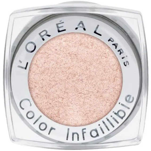 L’Oréal Paris Infallible 020 Hourglass Beige eye makeup. A 24-hour liquid-to-powder eyeshadow in a luminous, pale champagne-beige shade with a subtle metallic shimmer, shown in a sleek clear tube