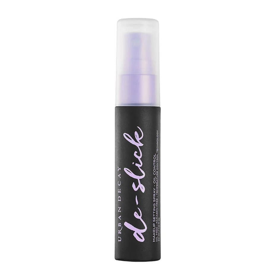 A 118ml bottle of Urban Decay De-Slick Oil Control Makeup Setting Spray. The bottle is sleek grey with a purple mist-dispensing nozzle and a translucent cap, standing upright against a clean, neutral background