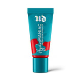 Urban Decay Hydromaniac Dewy Liquid Blush in shade “Red Flag,” a bold berry-red liquid blush in a sleek tube, with dewy texture swatched on cheeks and hand.