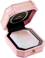Too Faced Diamond Light Highlighter in Diamond Fire shown in its signature jewel-box packaging, with the highlighter’s prismatic, multi-tone shimmer swatched on skin for a radiant, holographic glow.