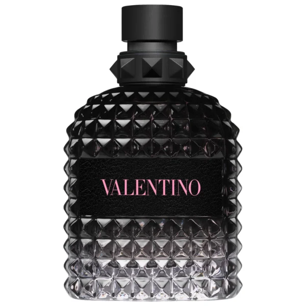 A single bottle of Valentino Born In Roma For Him Eau de Toilette. The signature black bottle features the iconic Valentino rockstud texture with a vibrant pink 'Roma' logo. The liquid inside is a cool, clear violet-grey